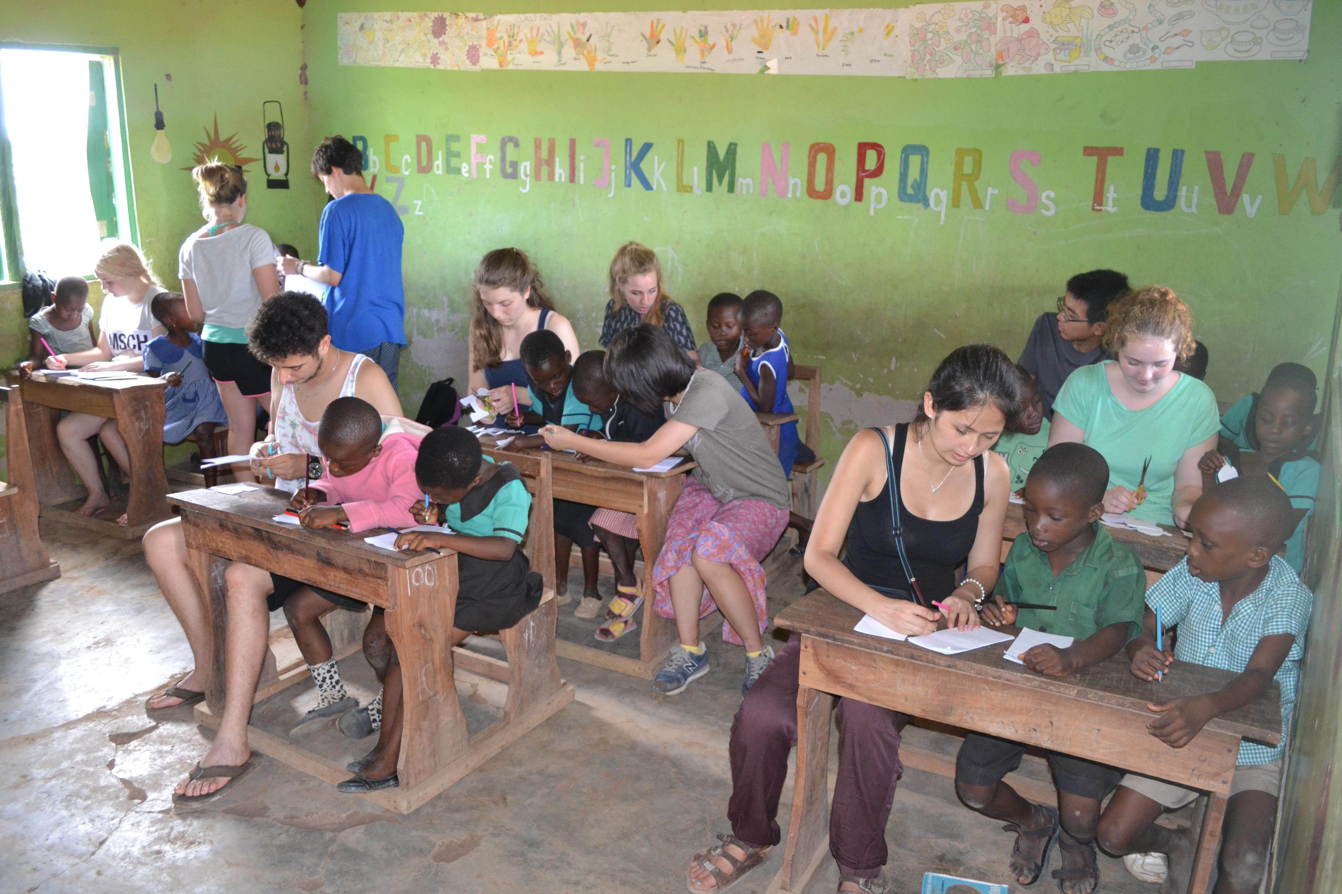 Childcare volunteers in Ghana help children with arts and crafts activities at a school. Projects Abroad volunteers help kindergarten children in Ghana with crafts activities at a local school.